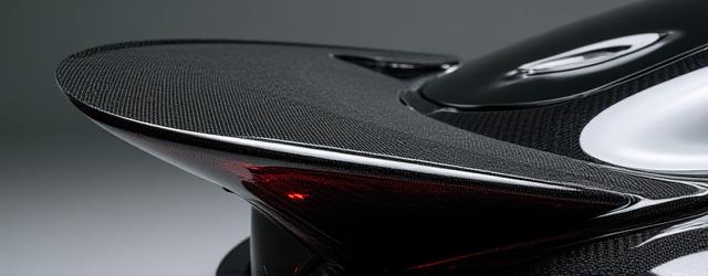 Carbon fiber rear spoiler with an immaculate, high-gloss finish before painting, showing complex aerodynamic curves.